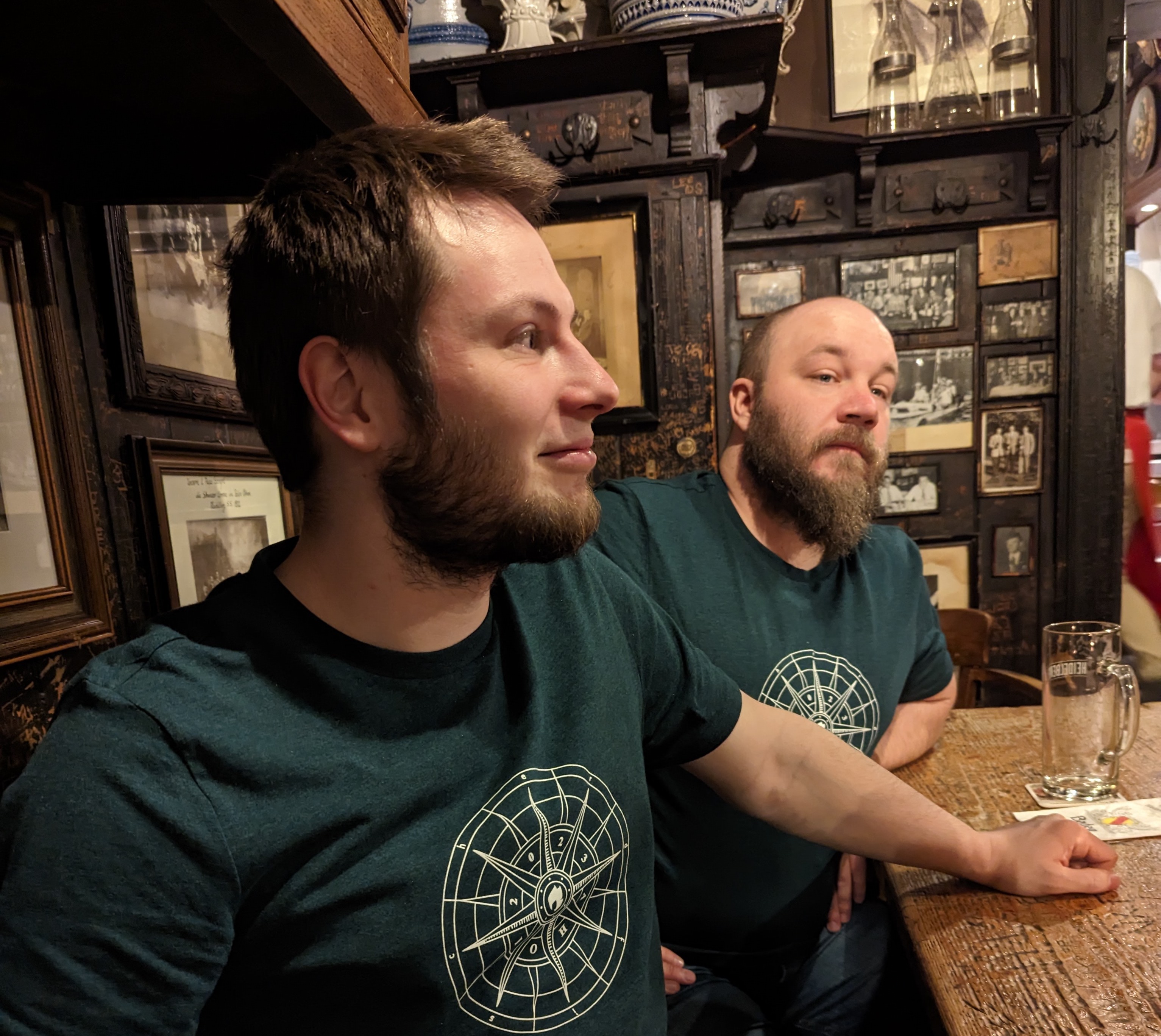 Henjo und Lothar tragen erdfisch Shirts und sitzen in einem Lokal