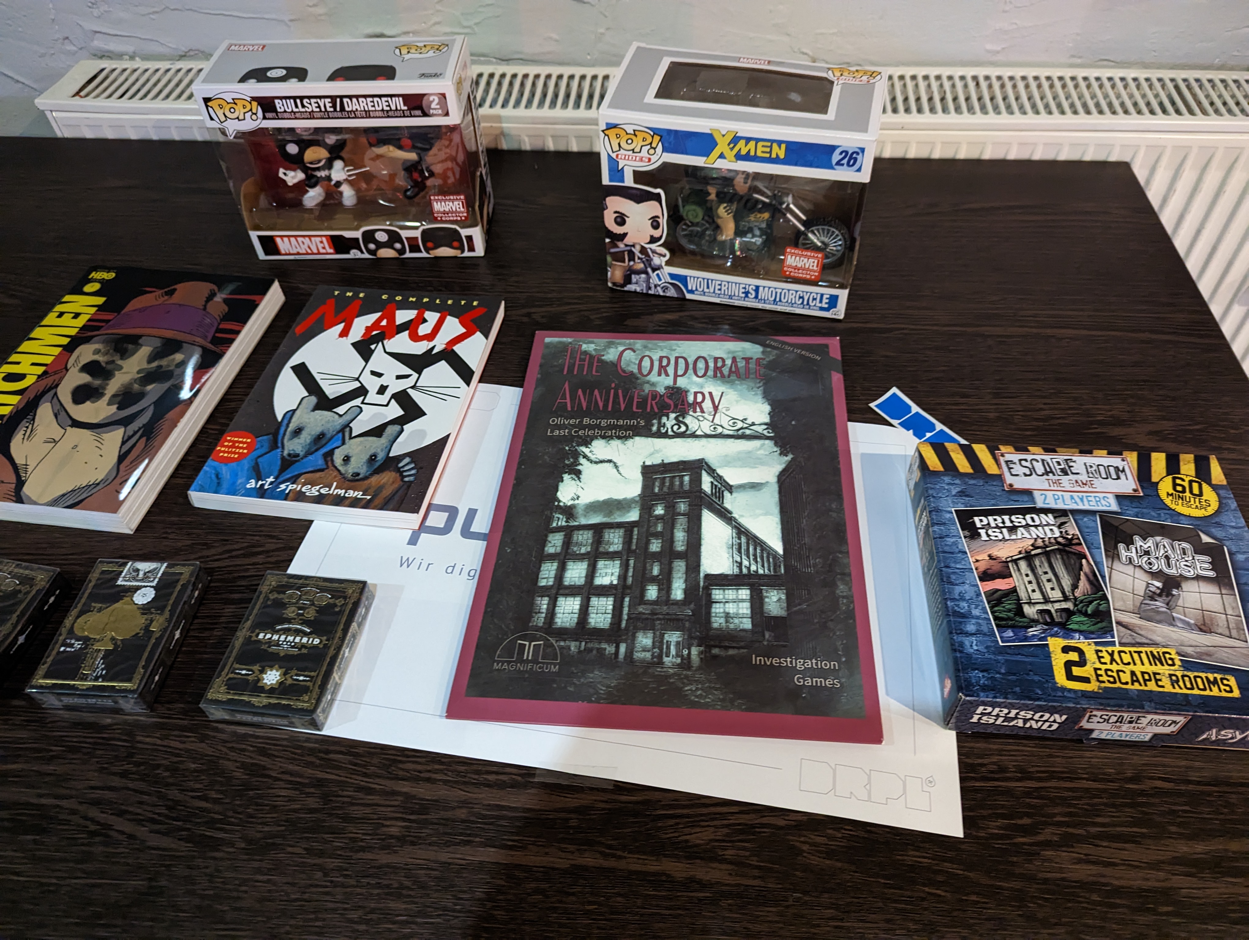 Nerdstuff, wie Comics und Funko Pops liegen ausgebreitet auf einem Tisch