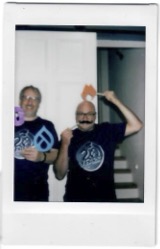 Frank und Fabian posieren mit erdfisch- und Drupal-Logos am Stiel