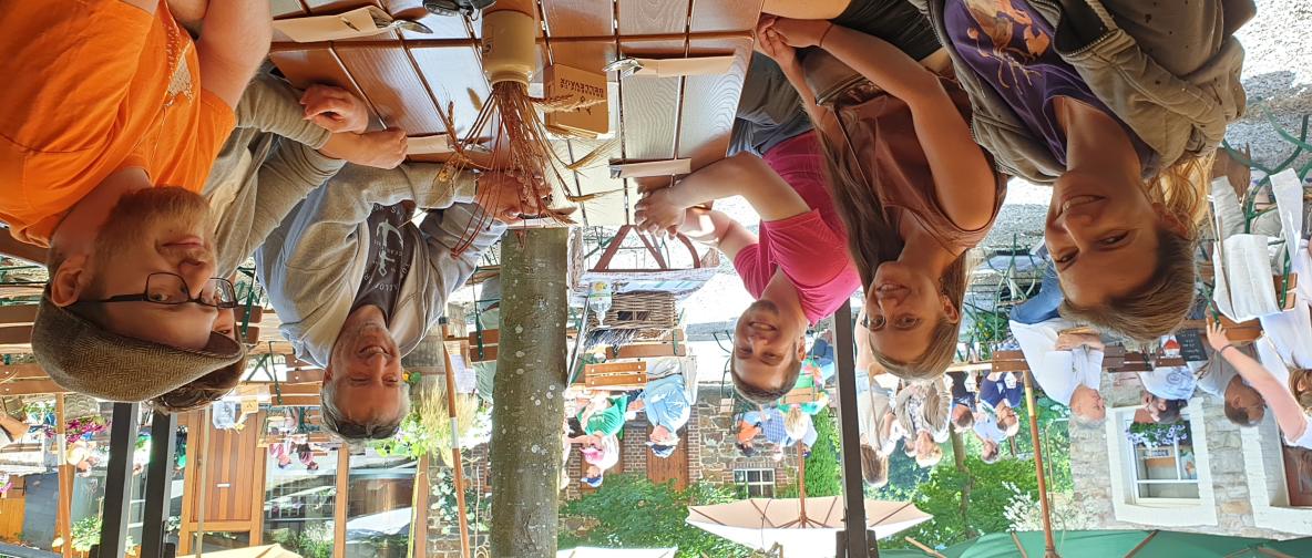 Eine Gruppe sitzt in einem Biergarten um einen Tisch.