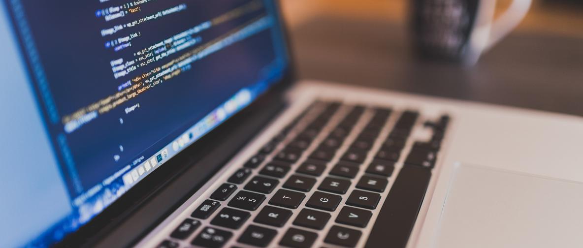 Ein Laptop, der Code auf dem Bildschirm zeigt.