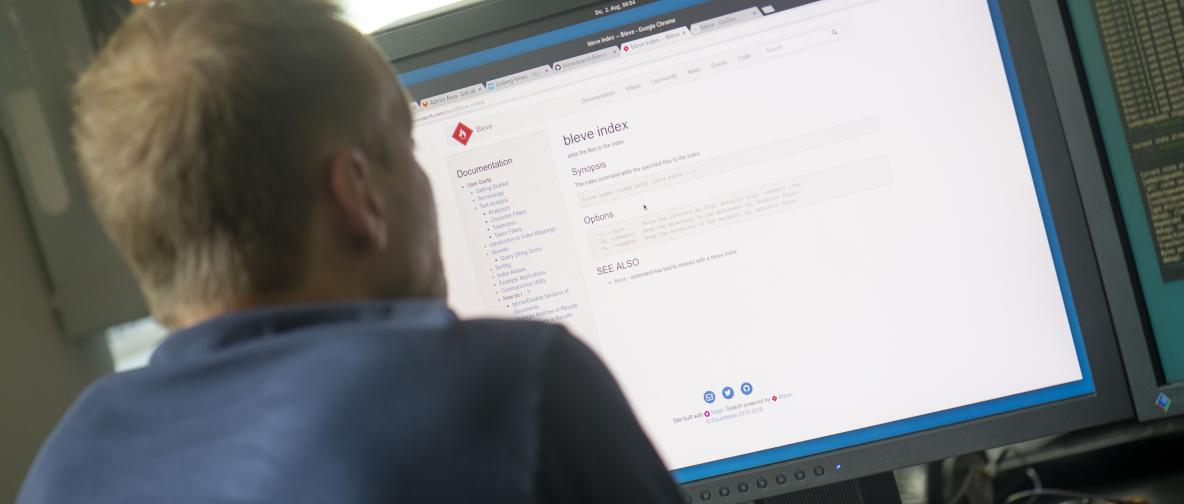 erdfisch Mitarbeiter sitzt vor einem Computerbildschirm und liest die technische Dokumentation zu einer Software.