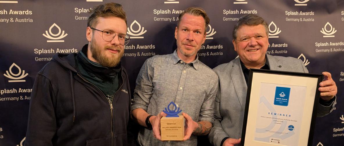 Ein Mitarbeiter der Agentur erdfisch und zwei Kundenvertreter bei den Splash Awards 2024 in Deutschland, mit ihrem gewonnenen Preis in der Kategorie E-Commerce. Zwei halten stolz die Trophäe und die Urkunde des gewonnenen Projekts „Linexo Multidomain-Konzept“ in den Händen.
