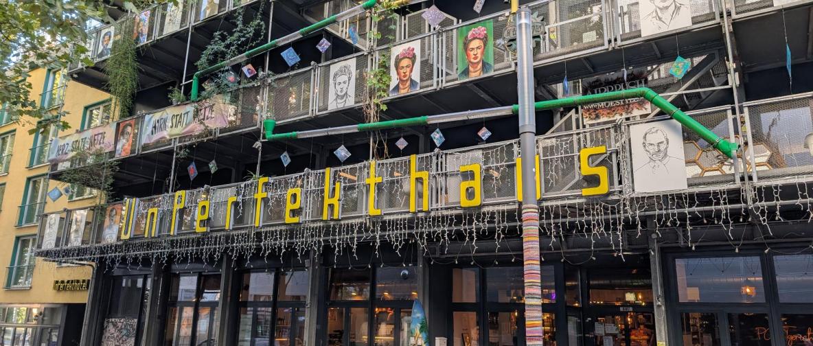 Gebäude mit vielen Dekorationen und Schriftzug „Unperfekthaus“ an der Fassade.