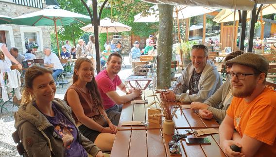 Das erdfisch Team sitzt zusammen an einem Biergarten-Tisch