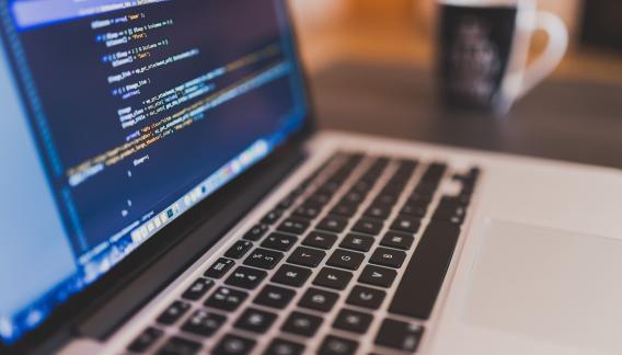 Ein Laptop, der Code auf dem Bildschirm zeigt.