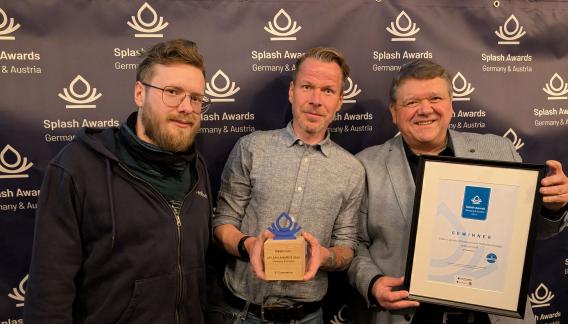 Ein Mitarbeiter der Agentur erdfisch und zwei Kundenvertreter bei den Splash Awards 2024 in Deutschland, mit ihrem gewonnenen Preis in der Kategorie E-Commerce. Zwei halten stolz die Trophäe und die Urkunde des gewonnenen Projekts „Linexo Multidomain-Konzept“ in den Händen.