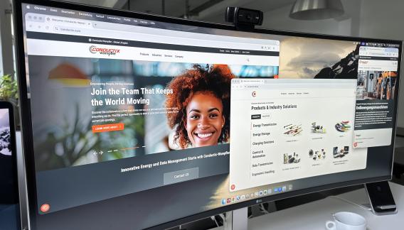 Widescreen-Monitor, der verschiedene Ansichten der Conductix Wampfler Webseiten zeigt